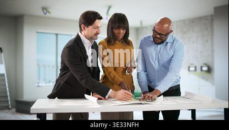 Young Designer Meets Couple, Discussing Apartment Remodeling And Finance Advice. A Professional Consultant Stock Photo