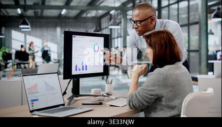 Woman And Man Analyzing Data On Laptops While Managing Business Performance Metrics. Two Analysts Stock Photo