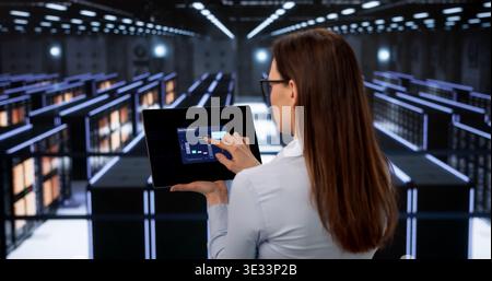 Female Data Technician Performs Thorough Security Checks In Cloud Server Room Stock Photo