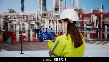Female Engineer Analyzing Industrial Energy Data On Tablet In Manufacturing Plant Stock Photo