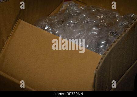 Macro closeup of clear bubble wrap inside open cardboard shipping box for packaging protection Stock Photo