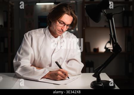 Doctor writing prescription, diagnosis or sick notes working on night shift at clinic. healthcare, medical treatment and medicine concept. copy space Stock Photo