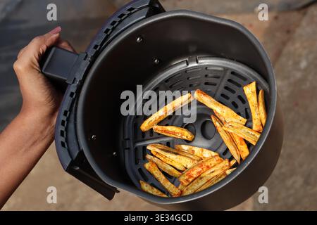 Air fryer tray with potato fries ready to be eaten after its airfried on the device Stock Photo
