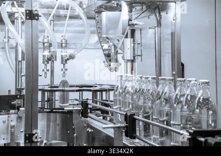 The hi-technology of drinking water manufacturing process. The empty drinking water bottles on the conveyor belt for filling process. Stock Photo