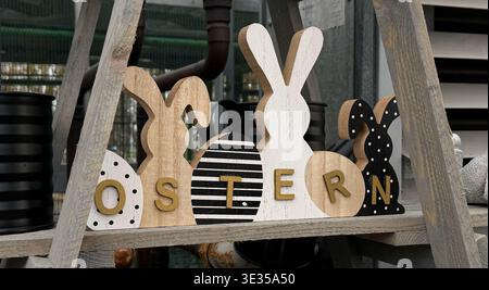 Decorative wooden bunnies and eggs spelling "OSTERN" displayed on a shelf Stock Photo