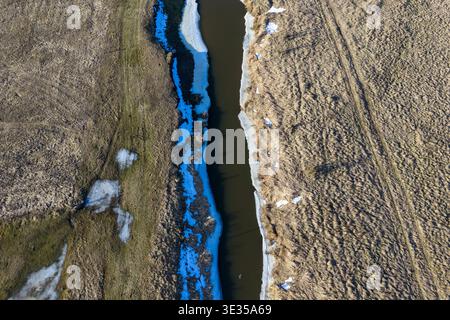 Aerial view of the narew river with melting ice and snow patches on dry fields in rural podlaskie voivodeship, poland Stock Photo