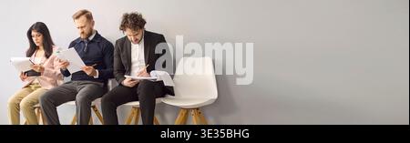 Job interview candidates waiting with resumes, business hiring concept, copy space Stock Photo