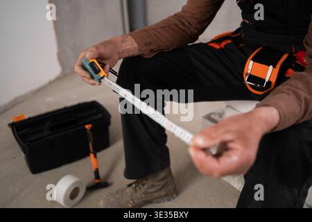 Architect holding tape measure. Civil engineer elderly senior man. Construction worker hold measuring tape. Retired builder worker. close-up Stock Photo