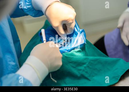 Dentist performing dental procedure with tools gloves and protective cover focusing on oral care hygiene treatment precision and professional clinical Stock Photo