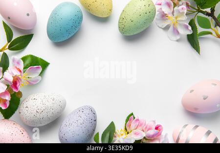 Colorful speckled and decorated easter eggs with delicate flowers on white background Stock Photo