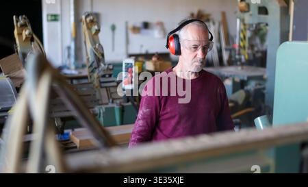 Experienced carpenter working with wood in workshop Stock Photo