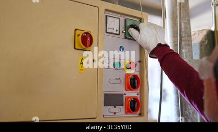 Worker in safety glove operating industrial machinery control panel Stock Photo