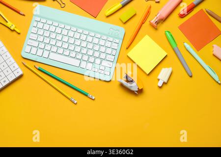 Composition with modern computer keyboard and different stationery on orange background Stock Photo