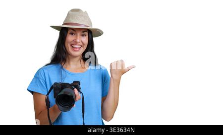 Happy woman tourist holding camera pointing to side Stock Photo