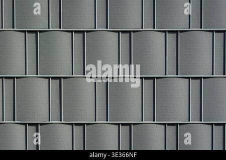 Repeating geometric pattern of grey metal panels forming a clean industrial surface. Stock Photo