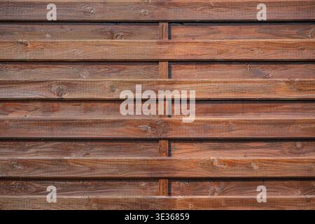 Close up view of a rustic wooden wall made of horizontal planks with natural grain and knots. Stock Photo