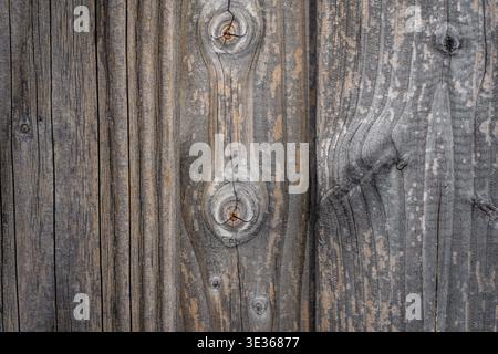 Close up of old weathered wooden boards with visible cracks, knots, and textured grain. Stock Photo