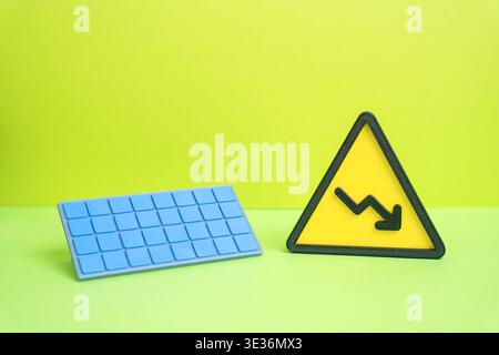 Solar panel and a downward arrow. Falling prices for solar technology and renewable energy equipment. Lower production costs but also reduced generati Stock Photo
