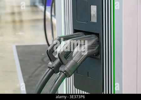 Industrial server or control unit with cooling fins, three black-connectored power cords two labeled, likely in an indoor utility setting Systematic e Stock Photo