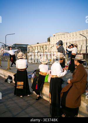 Wuhan, China - March 19, 2025: Performers in traditional attire practicing a cultural stilt dance at a public riverfront square. The image shows the p Stock Photo