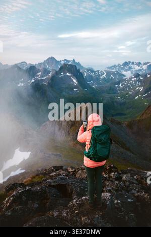 Woman hiker with smartphone and backpack gear climbing mountains using navigation application online, tourist girl on active adventure vacations extre Stock Photo