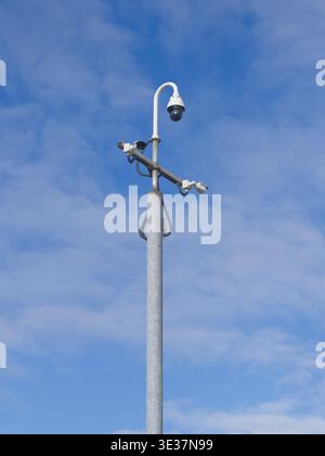 CCTV camera in sky watching people on street Stock Photo