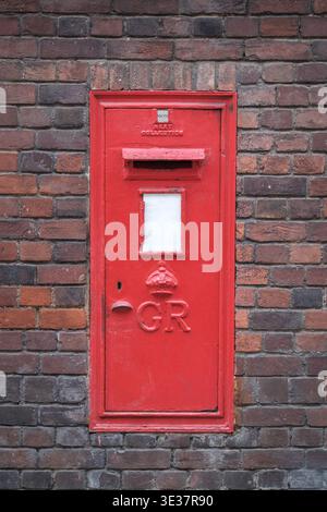 A Traditional Red British Wall Post Box Featuring The King George VI Cipher Set Into An Old Weathered Brick Wall In London Stock Photo