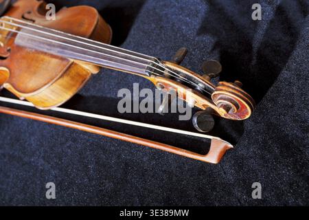 Violin pegbox and bow on black velvet background close up Stock Photo