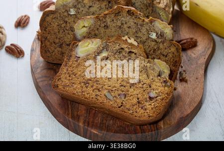 Homemade Banana Bread Slices with Nuts on Board Stock Photo