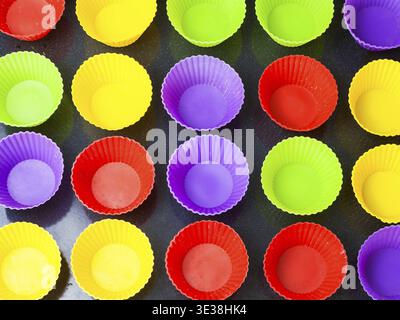 Top view of many empty multicolored silicone molds for muffins on baking tray Stock Photo