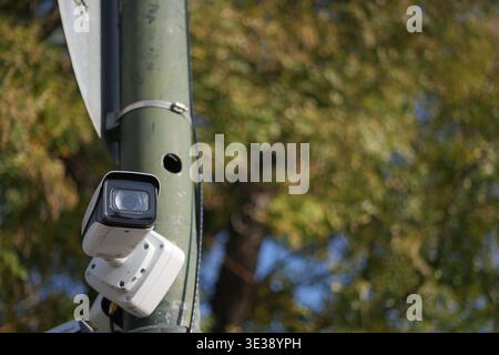 Security camera on a pole in a public area during daytime Stock Photo