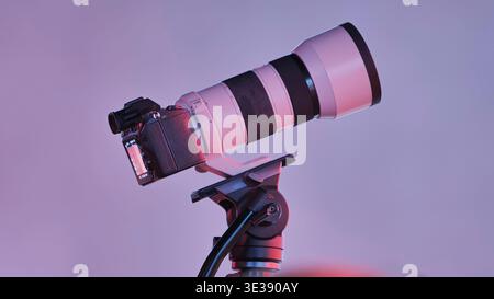 Mirrorless camera with telephoto lens on tripod capturing professional images Stock Photo