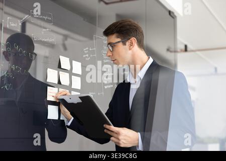 Serious man in glasses engage in brainstorming session in office Stock Photo