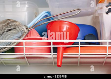 Kitchen utensils drying in a rack after washing. Household items arranged for drying. Everyday domestic routine and cleaning process in a kitchen. Stock Photo