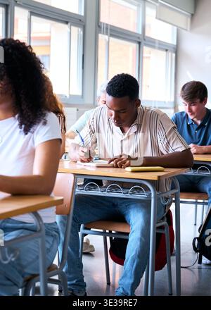 Focused students using laptop and writing in classroom Stock Photo