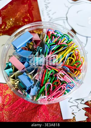 A storage container containing brightly coloured paper clips Stock Photo