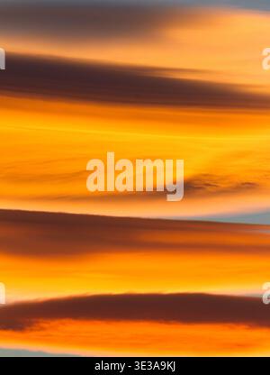 Fiery lenticular clouds glow orange over Canyonlands National Park, Utah at sunset. Stock Photo