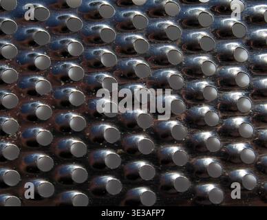Close up view of a grater perforated metal surface abstract textured background Stock Photo