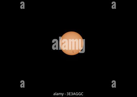 Single sun glows softly against a deep black sky. Its surface shows subtle flares and quiet imperfections. This celestial body radiates warmth and cal Stock Photo