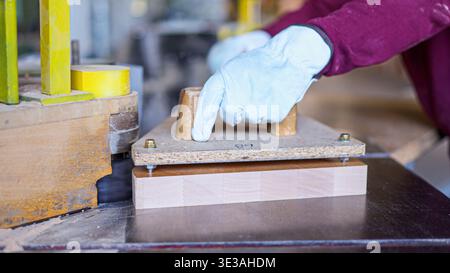 Carpenter cutting wood plank using spindler machine in workshop Stock Photo