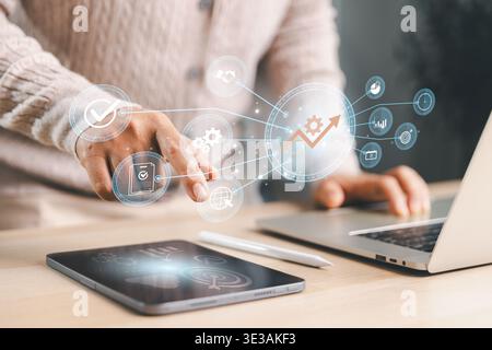 Professional using tablet and laptop with connected growth icons, showing productivity improvement, business strategy, performance tracking, workflow Stock Photo