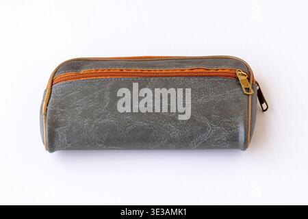 Close-up shot of a minimalist grey rectangular pouch featuring a textured surface and zip closure on white background. Excellent for depicting daily u Stock Photo