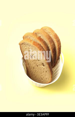 Slices of rye-wheat bread in a white basket Stock Photo