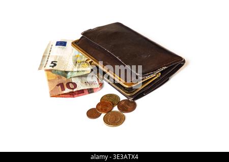 An old worn out leather purse with few euro notes and coins against white background Stock Photo