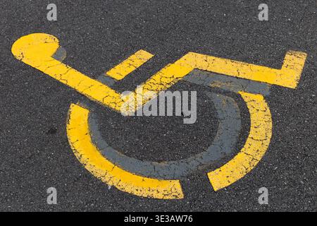 Wheelchair accessible parking symbol painted on asphalt. Stock Photo
