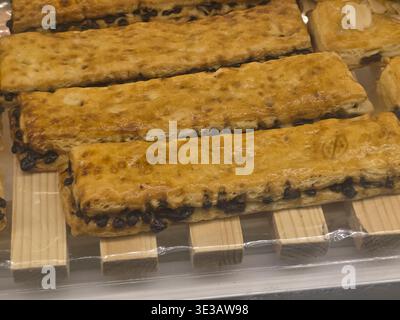 Delicious chocolate puff pastry sticks freshly baked on wooden rack. An appetizing and flaky sweet treat snack, perfect for breakfast or dessert at ba Stock Photo