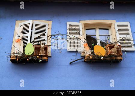 Charming handmade Easter nest with painted eggs displayed on a rustic wooden windowsill in Alsace, evoking spring traditions and cultural heritage Stock Photo