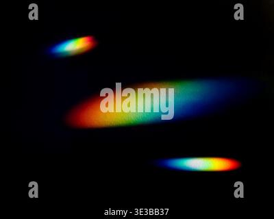 Vibrant spectrum of rainbow light beams on a black background, creating an abstract and colorful visual with glowing gradients. Stock Photo
