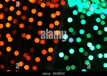 Orange green bokeh abstract background with vibrant glow. Festive light texture for events and nightlife design. Stock Photo