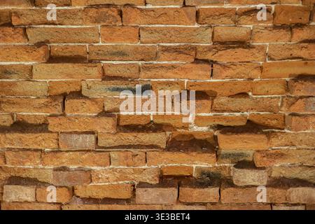 Ancient orange brick wall texture. Historical weathered masonry background with traditional terracotta tones for architectural heritage design. Stock Photo